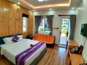 1 dormitorio con cama, sofá y ventanas en Phu Quoc Hotel en Phu Quoc