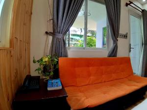 un sofá naranja en una habitación con ventana en Phu Quoc Hotel en Phu Quoc