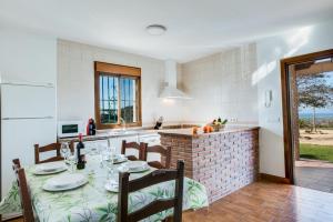 cocina y comedor con mesa y sillas en Casas Rurales El Mirador A, en Vejer de la Frontera