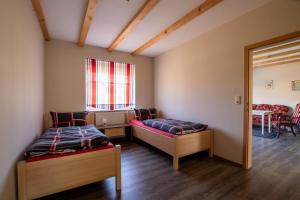 Una habitación con dos camas y una mesa y una ventana. en Apartmenthaus Djuren, en Dornum