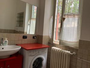 een badkamer met een wasmachine en een wastafel bij Appia Park apartament Roma in Rome