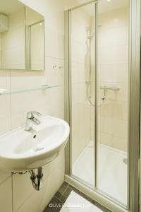 uma casa de banho branca com um lavatório e um chuveiro em Hotel Reiter Bräu em Wartenberg
