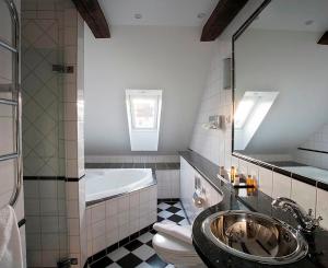 a bathroom with a sink, bathtub, and toilet at Mayfair Hotel Tunneln in Malmö