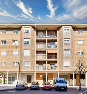 een appartementengebouw met ervoor geparkeerde auto's bij Housingleón - Parque de las Artes con Garaje in León