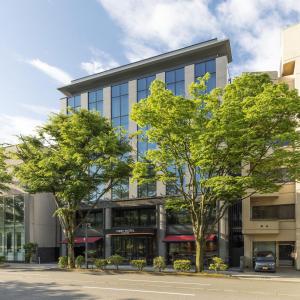 um edifício de escritórios com árvores em frente em First Hotel Kanazawa em Kanazawa