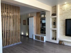 a living room with a television and a brick wall at Apartamento precioso a dos minutos de la playa in Santa Pola
