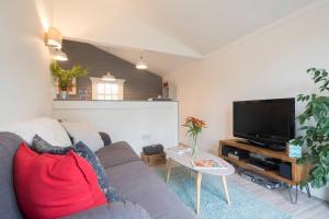 a living room with a couch and a flat screen tv at Walnut Tree Lodge in Aylsham