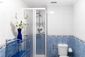 een badkamer met een toilet en een vaas met bloemen bij Housingleón - Parque de las Artes con Garaje in León