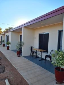 eine Terrasse mit einem Tisch und Stühlen auf einem Haus in der Unterkunft Safari Lodge Motel in Tennant Creek