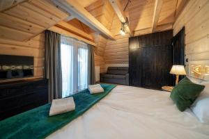 Posteľ alebo postele v izbe v ubytovaní "Osada Guty" - każdy domek posiada prywatne jacuzzi na wyłączność, w cenie pobytu - idealne miejsce na wypoczynek!