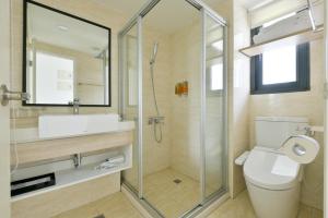 uma casa de banho com um chuveiro, um WC e um lavatório. em Hotel Kuei em Taichung