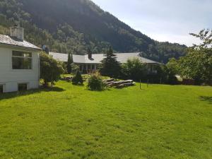 a house in a field of green grass with a mountain at Folgefonn Gjestetun in Jondal