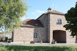 un vecchio edificio in mattoni con un grande garage di Gite Prairie Fleurie a Mai Cornet