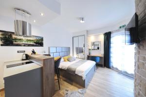 a bedroom with a bed and a kitchen with a sink at Villa Dalmatino in Pakoštane