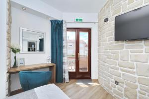 a room with a stone wall with a tv on a wall at Villa Dalmatino in Pakoštane