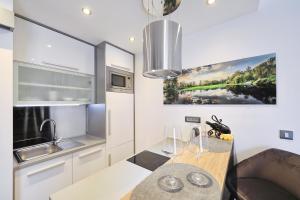 a kitchen with a sink and a wooden table at Villa Dalmatino in Pakoštane