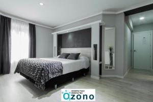 sypialnia z łóżkiem i dużym oknem w obiekcie Hostal Overnight Madrid w Madrycie