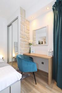 een slaapkamer met een bureau en een blauwe stoel bij Villa Dalmatino in Pakoštane