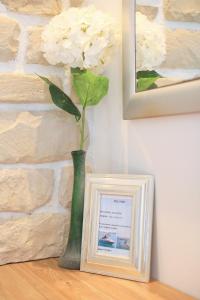 a vase with a flower in it next to a picture at Villa Dalmatino in Pakoštane