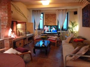 a living room with a couch and a tv at Domaine Le Village in Villenouvelle