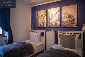 a bedroom with two beds and pictures on the wall at ApartOne Altstadt-Hotel in Bautzen