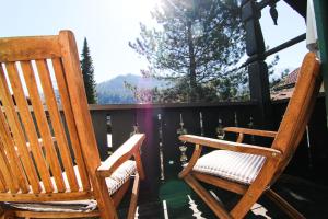 2 sillas de madera sentadas en un porche con vistas en Alpenlodge, en Garmisch-Partenkirchen