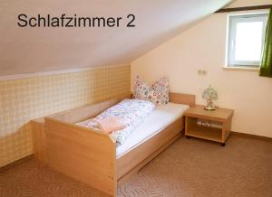a small bedroom with a bed and a table at FeWo Berghex in Pinswang