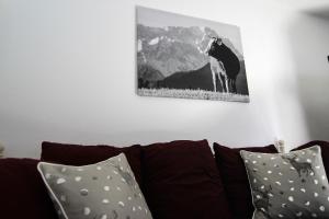 ein Bild einer Kuh an der Wand über einer Couch in der Unterkunft Alpenlodge in Garmisch-Partenkirchen