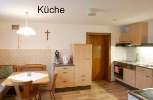 a kitchen with a table and a cross on the wall at FeWo Berghex in Pinswang +13 photos