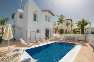 Villa con piscina frente a una casa en Katerina Luxury Villas, en Protaras