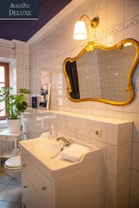 uma casa de banho com um lavatório, um espelho e um WC. em ApartOne Altstadt-Hotel em Bautzen