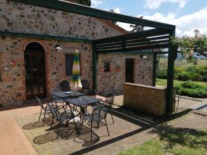 een patio met een tafel en stoelen voor een gebouw bij Relais Poggio al Vento in Pomarance