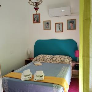una camera da letto con un letto blu con due asciugamani di Stella di mare a Cagliari