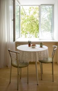 a table and two chairs in a room with a window at Apartments near Gogol theater in Poltava