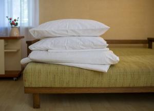 a stack of white pillows sitting on top of a bed at Apartments near Gogol theater in Poltava