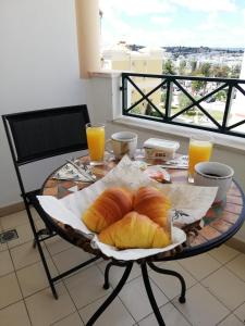 a table with a plate of bread and orange juice at Two Bedroom Apartment - 110m2, AC, Terrace, Wi-Fi in Lagos
