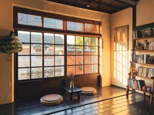 a living room with a large window and a table at 眷待期休憩所眷村民宿 in Kaohsiung