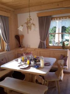 a dining room table with a white table and chairs at Bergpension-Ebental in Brixen im Thale