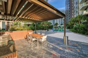 un patio con una mesa de madera y sillas bajo una pérgola en Perfect short term stay in Brissy Cozy & Relax en Brisbane