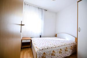 una piccola camera con letto e finestra di Apartmani Milka Zadar a Zara (Zadar)