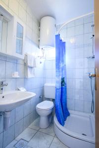uma casa de banho branca com um WC e um lavatório em Apartmani Milka Zadar em Zadar