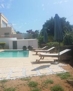- une piscine avec des chaises et des parasols à côté d'un bâtiment dans l'établissement 34 on Milkwood, à Durban