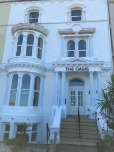 un edificio blanco con una señal que lee el oasis en The Oasis, en Llandudno