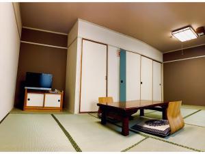 a dining room with a table and a tv at Hotel Hashimoto in Sapporo