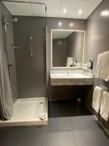 W łazience znajduje się prysznic, umywalka i lustro. w obiekcie Holiday Inn Express San Sebastian de los Reyes, an IHG Hotel w mieście San Sebastián de los Reyes