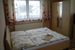 een klein bed in een slaapkamer met een raam bij Penzion Jaraba in Žiar