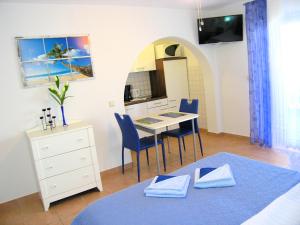a bedroom with a bed and a table with chairs at apartmani Žganec in Baška