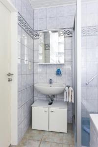 a white bathroom with a sink and a mirror at Ferienhaus Nordseeliebe in Esens +67 photos