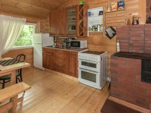Somerniemi的住宿－Holiday Home Lampimökki by Interhome，厨房配有木制橱柜和白色炉灶烤箱。