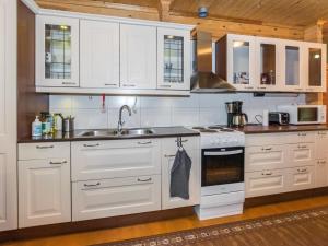 - une cuisine avec des placards blancs et un évier dans l'établissement Holiday Home Kuusela by Interhome, à Somerniemi